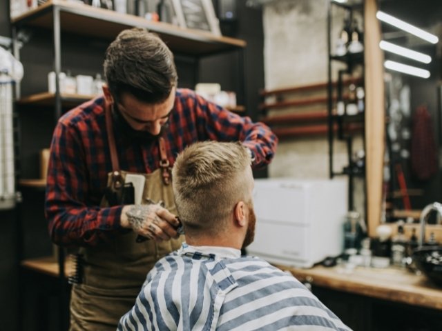 Curso de barbeiro online - Imagem profissional trabalhando em pé com a máquina 