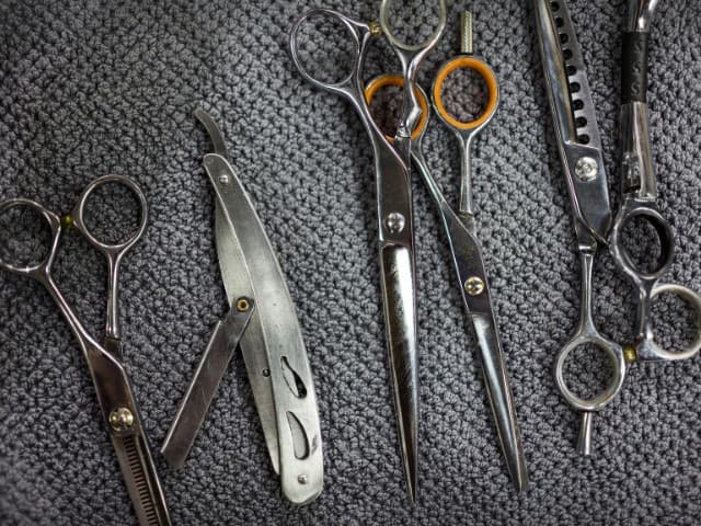 fotografia de diversos tipos de tesouras, uma das ferramentas essenciais para barbeiros